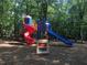 Colorful playground with slides and climbing structures nestled among mature trees at 305 Burkwood Ln, Raleigh, NC 27609