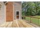 View of the exterior wooden deck with black metal railing and an access door to the home's interior at 310 Cross Lake, Fuquay Varina, NC 27526