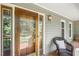 Cozy front porch featuring a wooden door, wicker chair, and charming details at 310 Cross Lake, Fuquay Varina, NC 27526