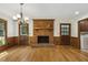 Bright living room featuring a brick fireplace, hardwood floors, and wood paneling at 310 Cross Lake, Fuquay Varina, NC 27526