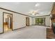 Open living room with fireplace, hardwood trim, and view of kitchen appliances at 310 Cross Lake, Fuquay Varina, NC 27526
