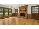 Cozy living room boasts a charming brick fireplace, hardwood floors, and natural light at 310 Cross Lake, Fuquay Varina, NC 27526