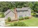 View of home's rear exterior featuring a deck, complemented by mature trees and a lush green lawn at 310 Cross Lake, Fuquay Varina, NC 27526