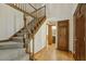 Carpeted staircase with wooden banister and hardwood floors leading to upstairs bathroom at 310 Cross Lake, Fuquay Varina, NC 27526