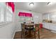 Bright dining area featuring a round table and four chairs, complemented by natural light from nearby windows at 313 Colleton Rd, Raleigh, NC 27610