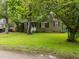 This beautiful home features a large lawn, mature trees, and a classic exterior design with black shutters at 313 Colleton Rd, Raleigh, NC 27610