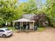 Backyard view of home featuring a covered patio and ample parking space surrounded by lush greenery at 313 Colleton Rd, Raleigh, NC 27610