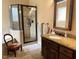 Bathroom with granite countertop, dark cabinets, and glass shower at 327 Beavertail Rd, Henderson, NC 27537