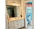 Bright bathroom with a white vanity, large mirror and a toilet with a window view at 327 Beavertail Rd, Henderson, NC 27537