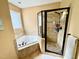 Bathroom with a glass shower and separate soaking tub under window at 327 Beavertail Rd, Henderson, NC 27537
