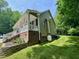 Exterior side view features manicured lawn, brick foundation, and a charming front porch at 327 Beavertail Rd, Henderson, NC 27537