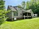 Rear exterior view of home with screened-in porch and lush green lawn at 327 Beavertail Rd, Henderson, NC 27537