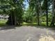 View from street showcasing the home's exterior and expansive backyard, framed by mature trees and lush greenery at 327 Beavertail Rd, Henderson, NC 27537