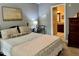 Main bedroom with a tray ceiling, neutral paint, and door to bathroom at 327 Beavertail Rd, Henderson, NC 27537