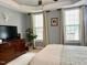 Main bedroom with a tray ceiling, neutral paint, and large dresser at 327 Beavertail Rd, Henderson, NC 27537