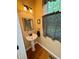 Cozy powder room with a pedestal sink, decorative mirror, and stylish wallpaper at 327 Beavertail Rd, Henderson, NC 27537