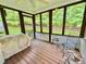 Cozy screened-in porch with wooden floors, a ceiling fan, and tranquil backyard views at 327 Beavertail Rd, Henderson, NC 27537