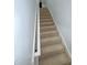 Carpeted stairway with white railing and neutral walls, providing a seamless transition between floors at 327 Beavertail Rd, Henderson, NC 27537