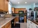 Traditional kitchen with oak cabinets, tile backsplash, stainless steel refrigerator and black appliances at 3507 Portico Ln, Durham, NC 27703