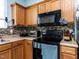Shows the kitchen featuring oak cabinets, black appliances, tile backsplash, and light countertops at 3507 Portico Ln, Durham, NC 27703