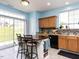 Kitchen including an island with chairs, oak cabinets, tile backsplash, stainless steel refrigerator, and sliding door at 3507 Portico Ln, Durham, NC 27703