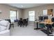 View of a carpeted living room featuring multiple windows and neutral color scheme with black dining table at 3507 Portico Ln, Durham, NC 27703