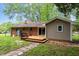 Backyard view showcasing a wooden deck, mature trees, and a combination of brick and siding exterior at 3515 Luna Ln, Durham, NC 27705