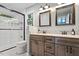Updated bathroom featuring a double vanity, stylish mirrors, and glass enclosed shower at 3515 Luna Ln, Durham, NC 27705