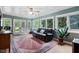 Bright sunroom filled with natural light, offering views of the landscaped yard, and a cozy seating area at 3515 Luna Ln, Durham, NC 27705