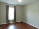 Bedroom featuring hard wood floors, window with dark grey curtains and neutral walls at 3803 Ridgewood Dr, Franklinton, NC 27525