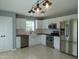 Well-lit kitchen with stainless steel appliances, white cabinets, and unique lighting at 3803 Ridgewood Dr, Franklinton, NC 27525