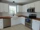 Bright kitchen with stainless steel appliances, white cabinets, and a farmhouse sink at 3803 Ridgewood Dr, Franklinton, NC 27525