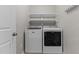 Well-lit laundry room with white washer and dryer, plus shelving for storage at 3803 Ridgewood Dr, Franklinton, NC 27525
