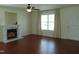 Cozy living room with hardwood floors, a fireplace, and a large window offering natural light at 3803 Ridgewood Dr, Franklinton, NC 27525