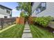 Landscaped backyard featuring green grass, stone pavers, and a wooden privacy fence at 409 E Lee St, Raleigh, NC 27601
