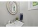Stylish half bathroom with modern fixtures, including a round mirror and sleek sink at 409 E Lee St, Raleigh, NC 27601