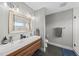 Modern bathroom with dual sinks, wood vanity, contemporary fixtures, and walk-in shower at 409 E Lee St, Raleigh, NC 27601