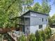 Two-story home with a gray exterior, deck, and balcony surrounded by lush trees at 409 E Lee St, Raleigh, NC 27601