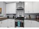 Contemporary kitchen with white cabinets, stainless steel appliances, and dark countertops at 409 E Lee St, Raleigh, NC 27601