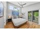 Relaxing bedroom with a ceiling fan, light hardwood floors, and access to an outdoor balcony at 409 E Lee St, Raleigh, NC 27601