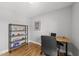 Bright home office featuring hardwood floors, a modern adjustable height desk and shelving unit at 409 E Lee St, Raleigh, NC 27601