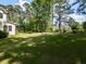 Large, green backyard with lush landscaping and trees; black iron fence in rear at 4104 Bankshire Ln, Raleigh, NC 27603
