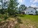 Spacious backyard with mature trees and lush lawn, showing home's exterior and screened porch at 4104 Bankshire Ln, Raleigh, NC 27603