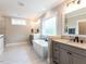 Relaxing bathroom showcasing a modern soaking tub, separate vanities, and wood-look tile flooring at 4104 Bankshire Ln, Raleigh, NC 27603
