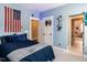 Blue bedroom featuring an American flag, a large bed, and an open door leading to another room at 4104 Bankshire Ln, Raleigh, NC 27603