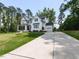 Stunning two-story white farmhouse featuring black shutters and a long concrete driveway at 4104 Bankshire Ln, Raleigh, NC 27603