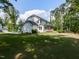 Exterior view of home showing white siding, green grass, mature trees, and screened-in porch at 4104 Bankshire Ln, Raleigh, NC 27603