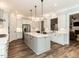 Modern kitchen with stainless steel appliances, white cabinets, a large island and hardwood floors at 4104 Bankshire Ln, Raleigh, NC 27603