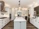 Bright kitchen featuring sleek white cabinets, a large island, and stainless-steel appliances at 4104 Bankshire Ln, Raleigh, NC 27603