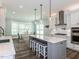 Bright kitchen features a center island, stainless hood, white cabinets and modern pendant lighting at 4104 Bankshire Ln, Raleigh, NC 27603